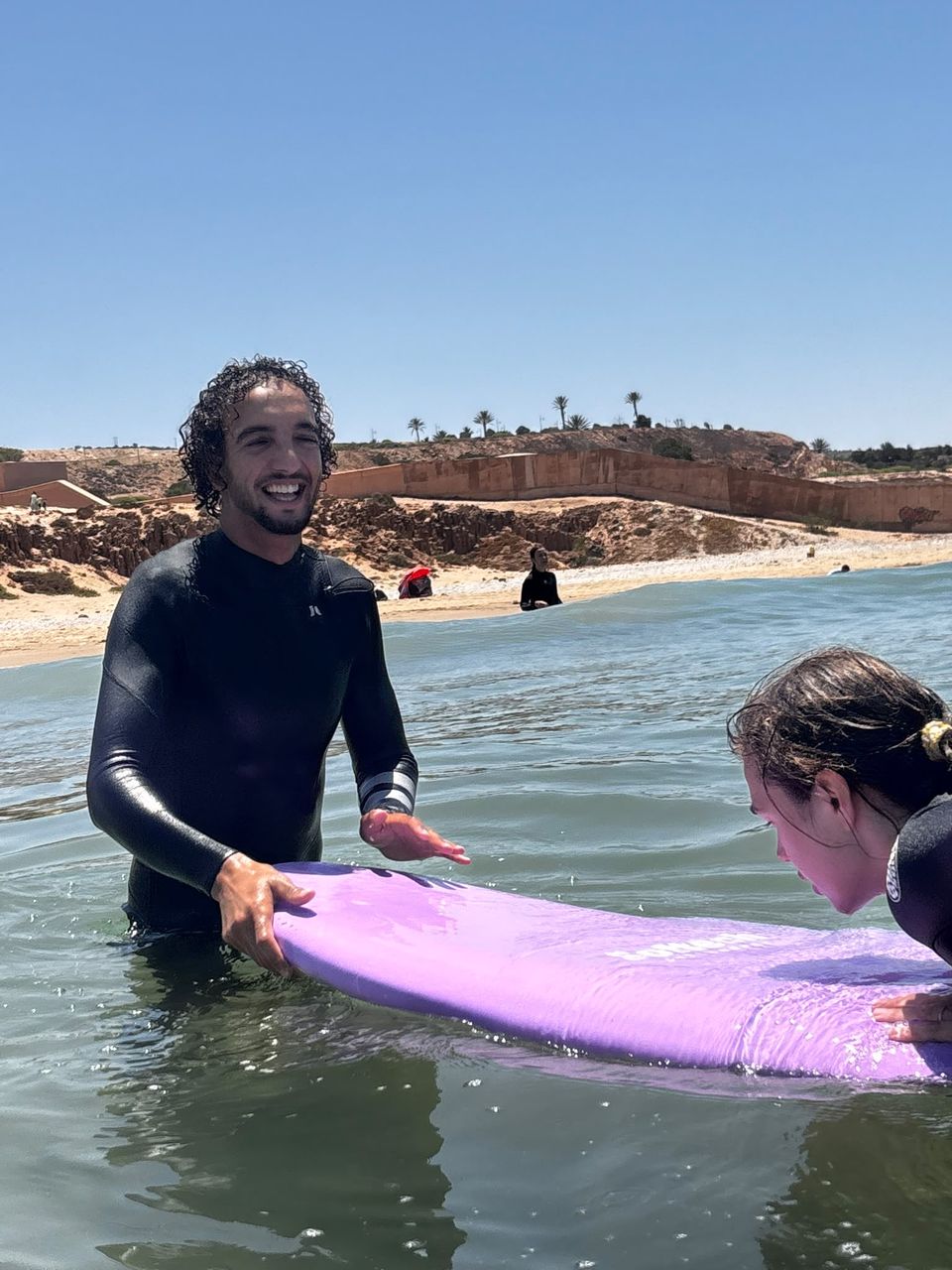 Coach Youness with a student in the water
