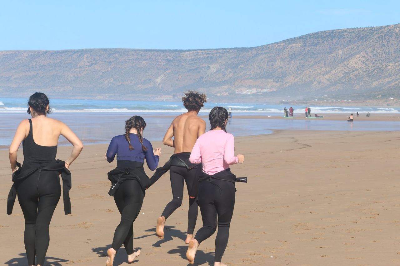 Students running into the ocean