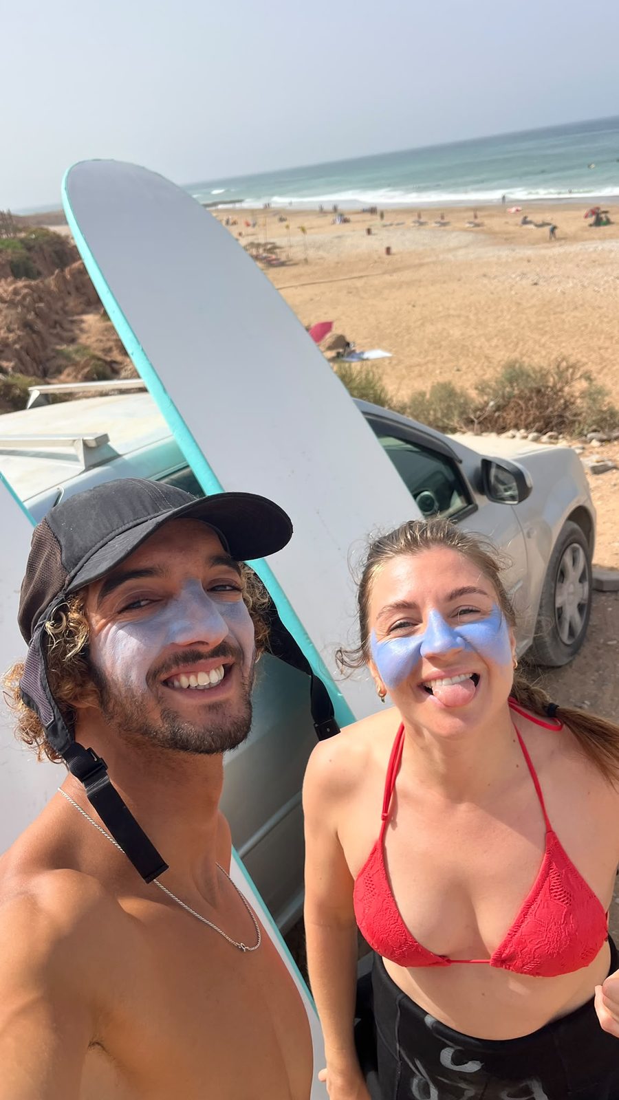 Youness and a student in zinc sunscreen before paddling out
